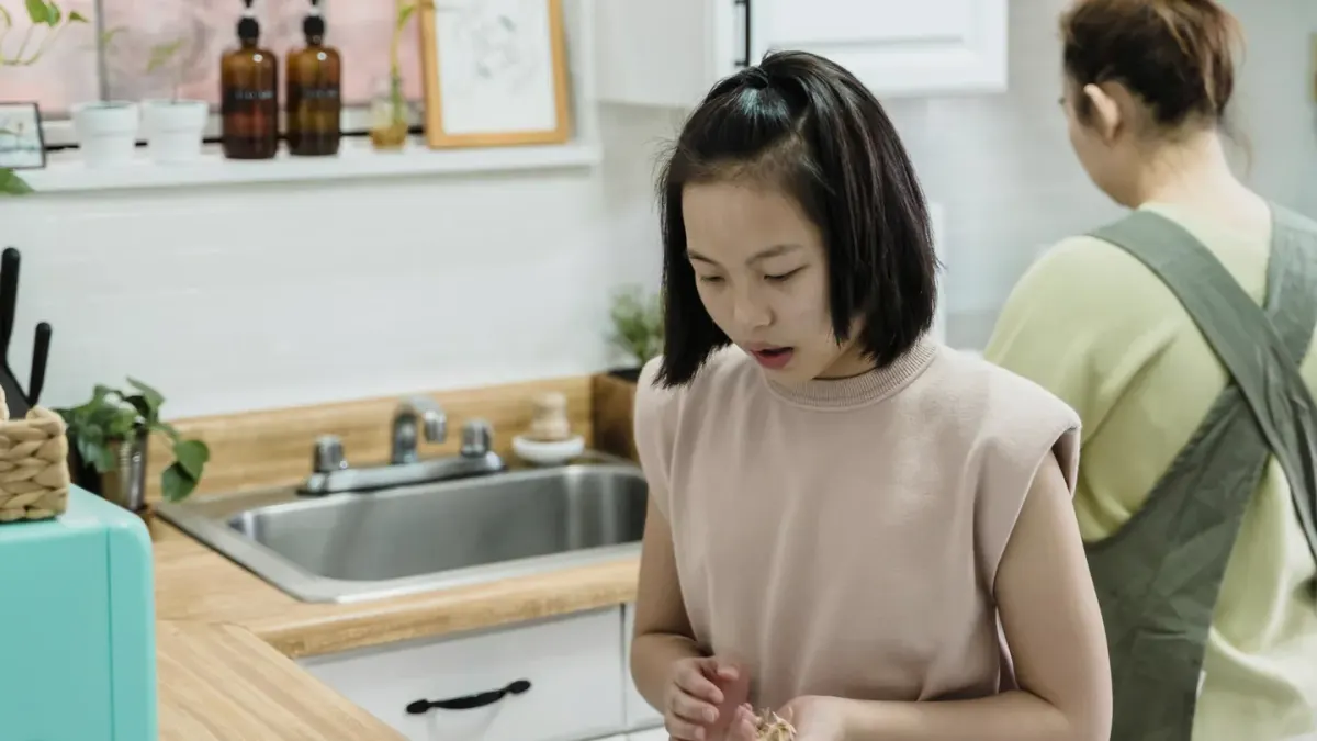 A bottle of elderberry gummies sitting on a kitchen counter near a curious dog