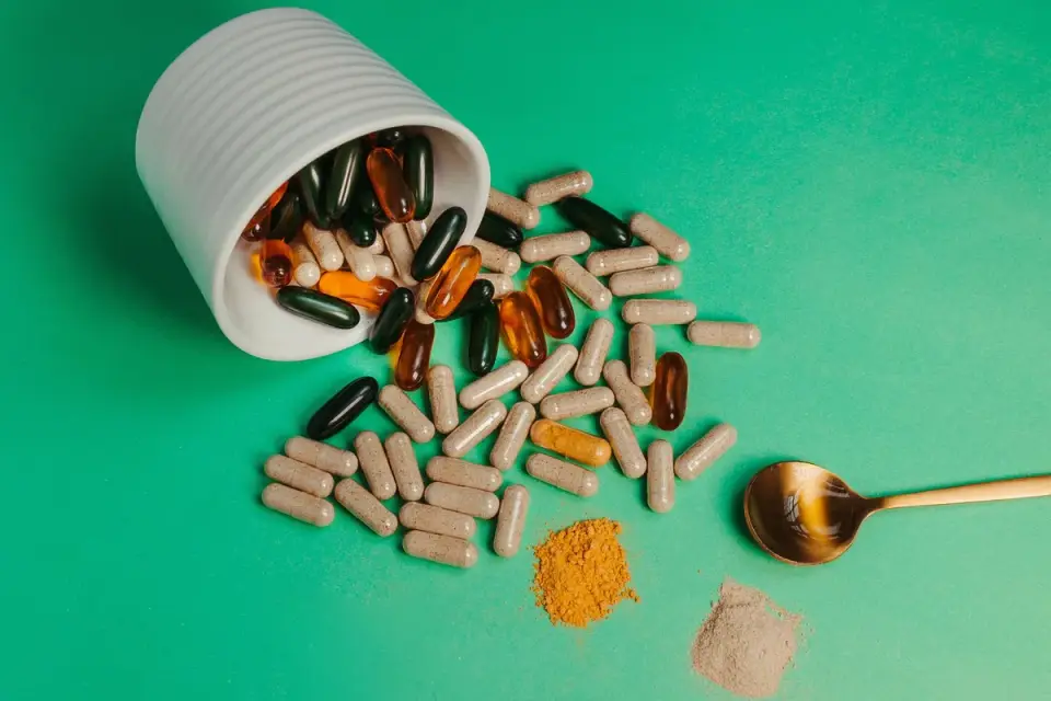 A dog food bowl with kibble next to a supplement powder scoop