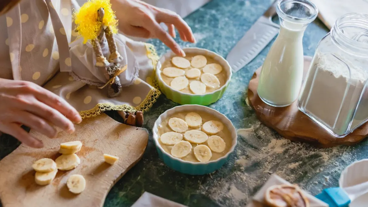 A dog sniffing thin banana slices on a kitchen counter