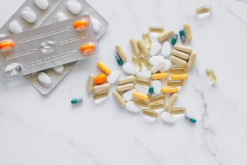 A handful of joint supplement chews next to a small dog bowl on a kitchen counter