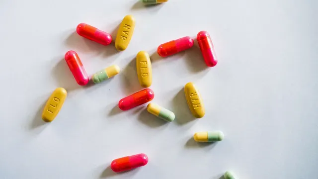 A pile of soft dog supplement chews next to a bottle of capsules on a kitchen counter