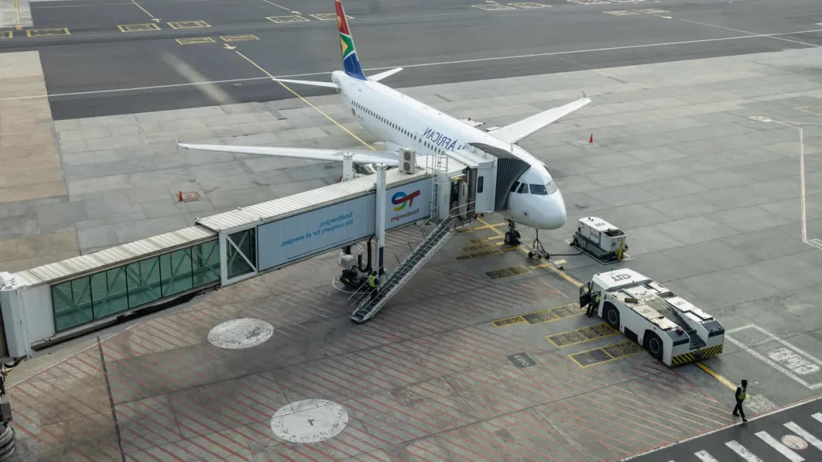 A small dog sitting calmly inside a soft-sided airline carrier at an airport gate