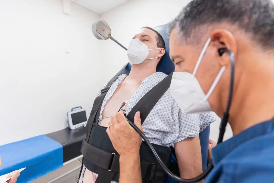 A veterinarian gently palpating a dog&#x27;s abdomen during an exam