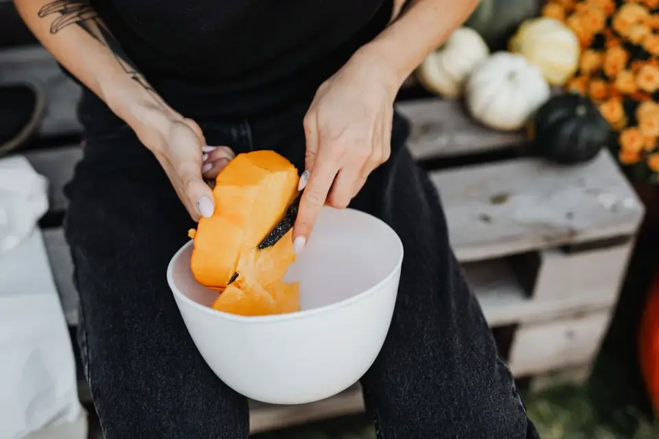 A veterinarian spooning pumpkin puree into a dog's food bowl