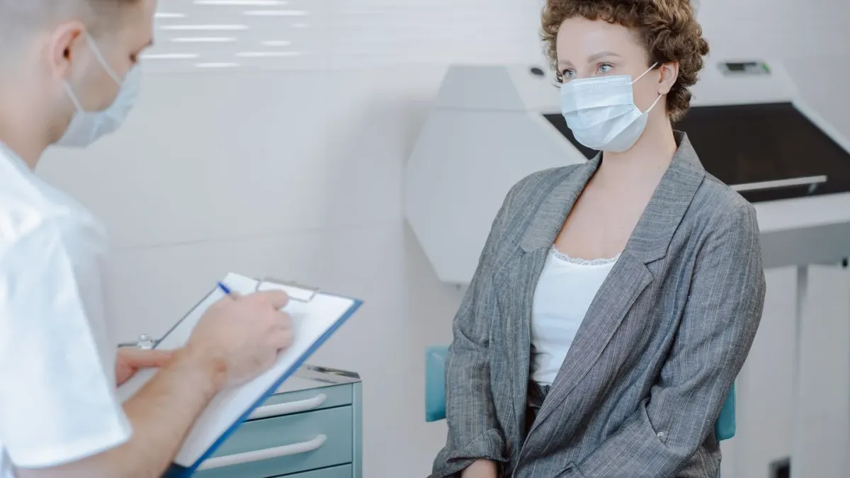 A veterinarian talking with a dog owner during a consultation, dog seated beside them