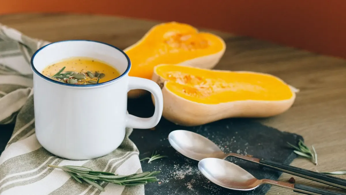 An open can of plain pumpkin puree beside a small jar of pumpkin powder and a measuring scoop