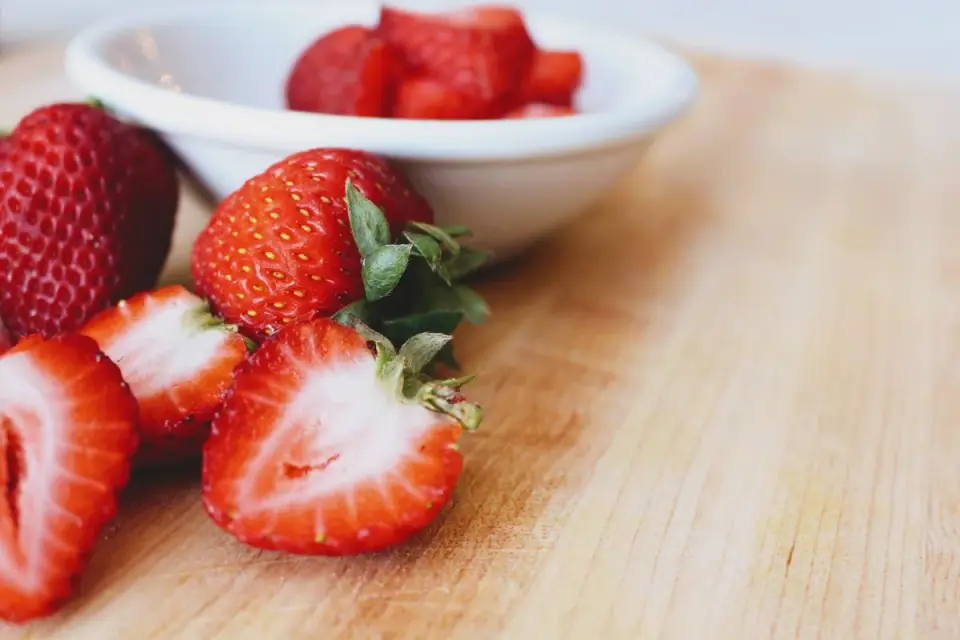 Fresh strawberries and apples arranged on a wooden table, natural sources of fisetin and quercetin