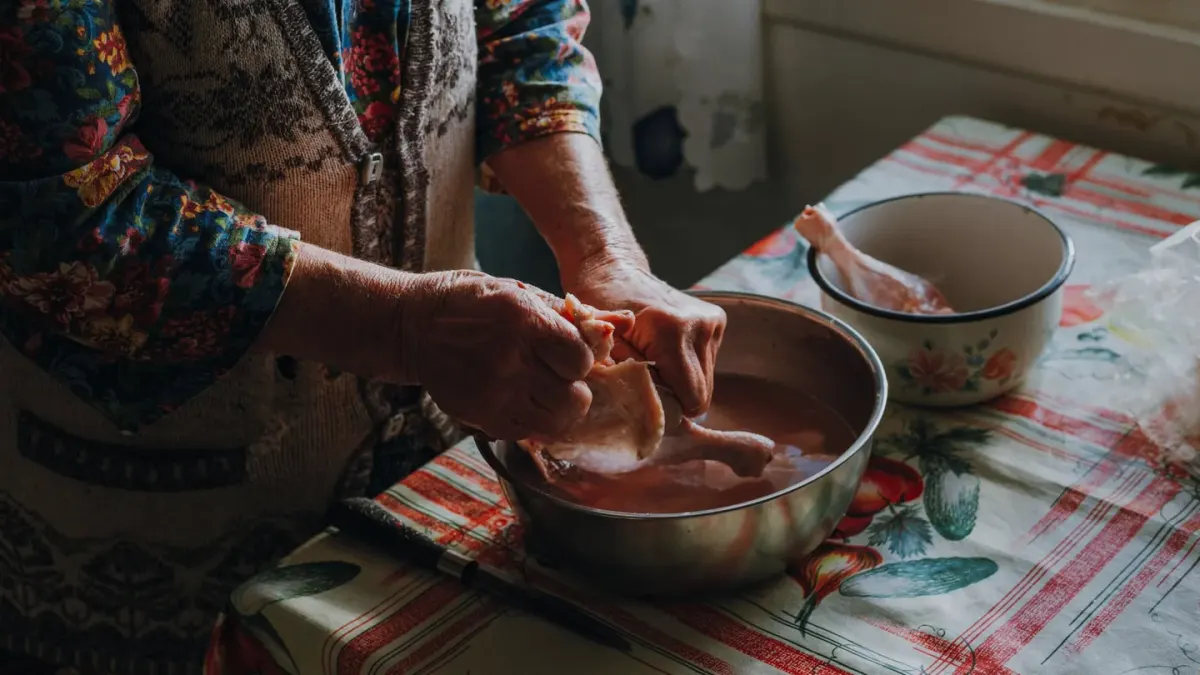 Senior golden retriever eating from a stainless steel bowl in a kitchen