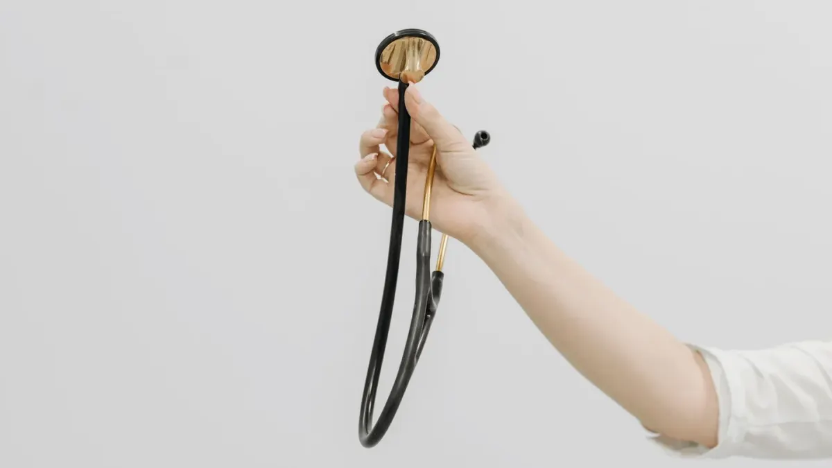 Veterinarian using a stethoscope to check a golden retriever's heart